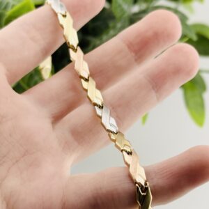 10K Yellow, White and Rose Gold Tri tone Bracelet. Ladies Link Cross Ribbon style with Lobster Clasp. 7" long. 4.75mm wide. 3.4 Grams