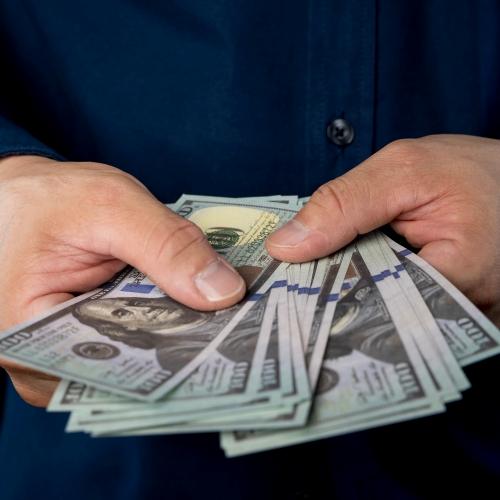 Big,Pile,Of,Money,Dollars,In,The,Hand.,Close,Up